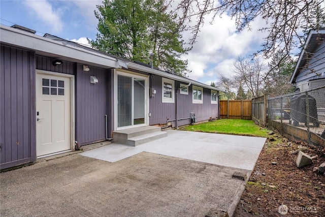 exterior space featuring entry steps, a patio area, a lawn, and a fenced backyard