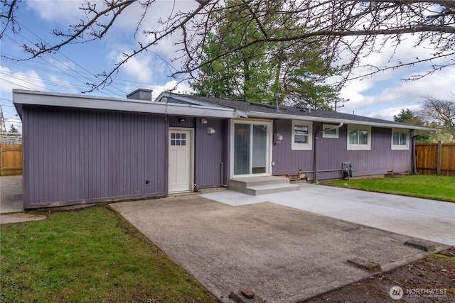 ranch-style home featuring a front lawn, a patio area, and fence