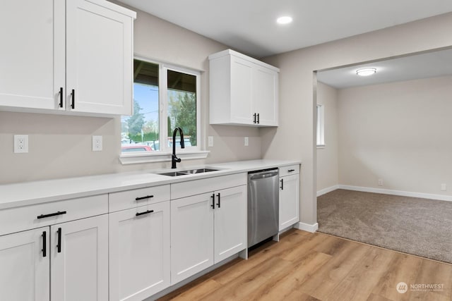 kitchen with white cabinets, light wood-type flooring, stainless steel dishwasher, and sink