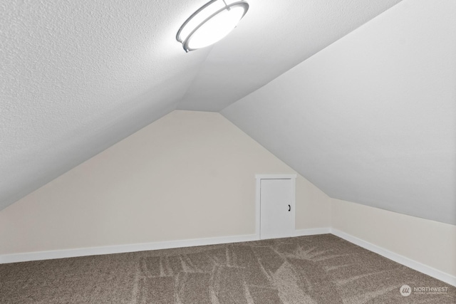 bonus room featuring a textured ceiling, carpet floors, and lofted ceiling