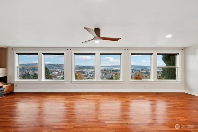 unfurnished living room featuring ceiling fan and light hardwood / wood-style flooring