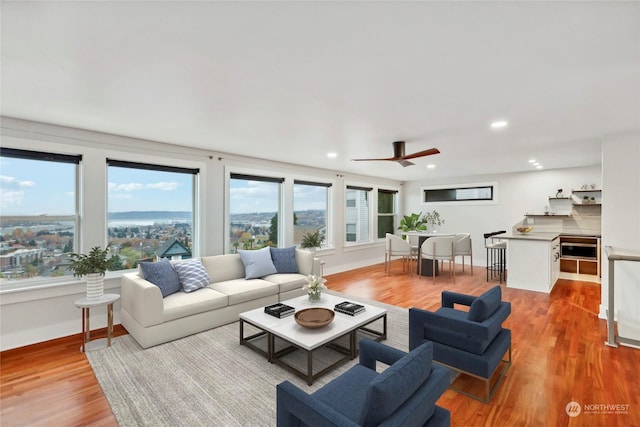 living room with light hardwood / wood-style flooring and ceiling fan