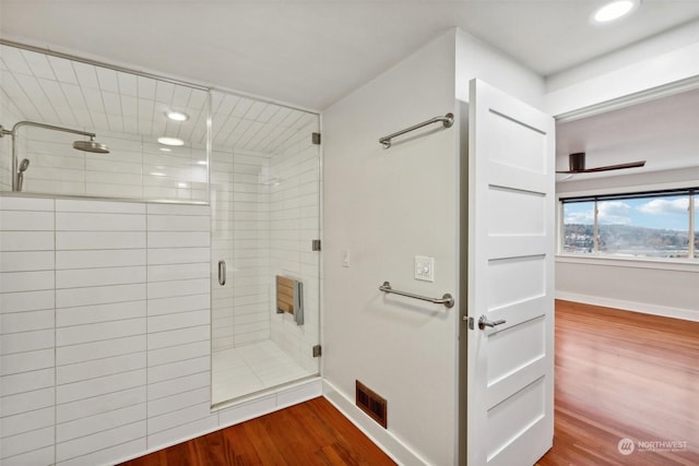 bathroom with wood-type flooring and a shower with shower door