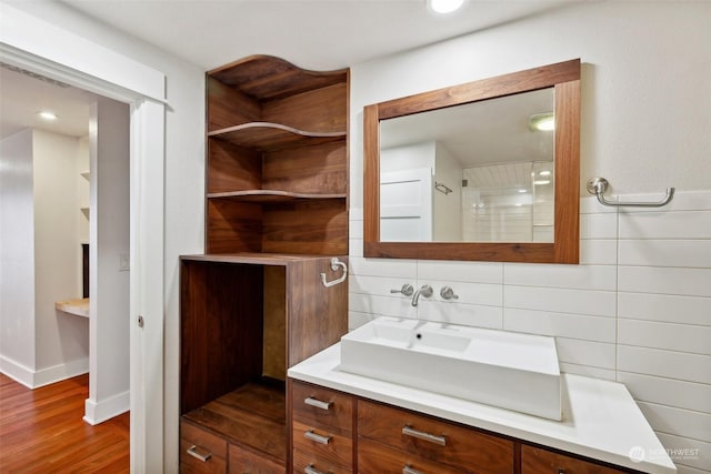 bathroom featuring hardwood / wood-style floors, vanity, and backsplash