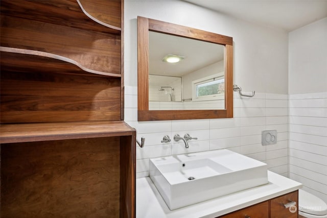 bathroom with vanity, tile walls, and toilet