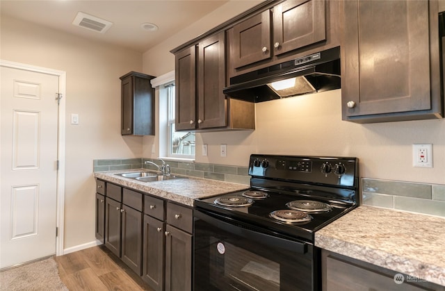 kitchen with black electric range, light hardwood / wood-style flooring, dark brown cabinets, and sink