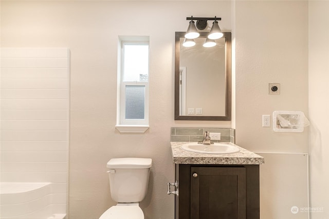 bathroom with a shower, vanity, and toilet