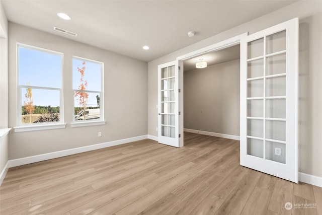 unfurnished room with light wood-type flooring and french doors