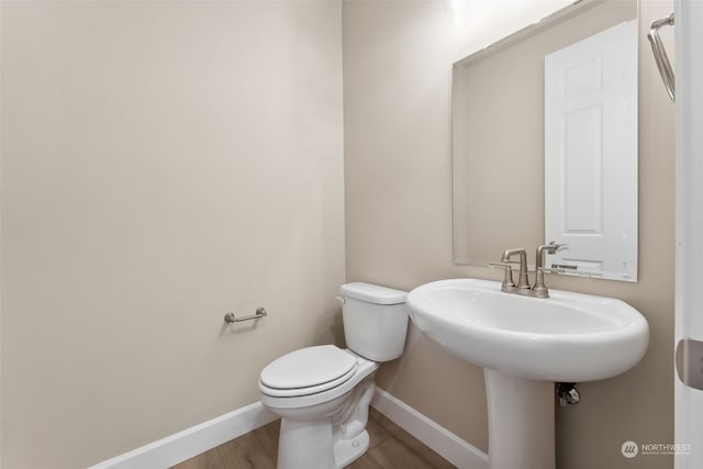 bathroom featuring hardwood / wood-style floors and toilet