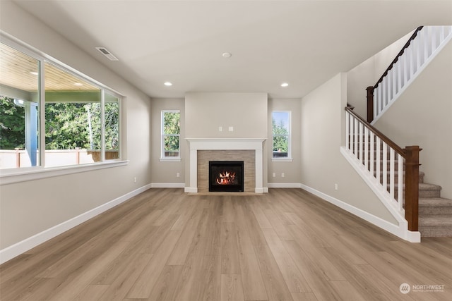 unfurnished living room featuring plenty of natural light, light hardwood / wood-style floors, and a fireplace