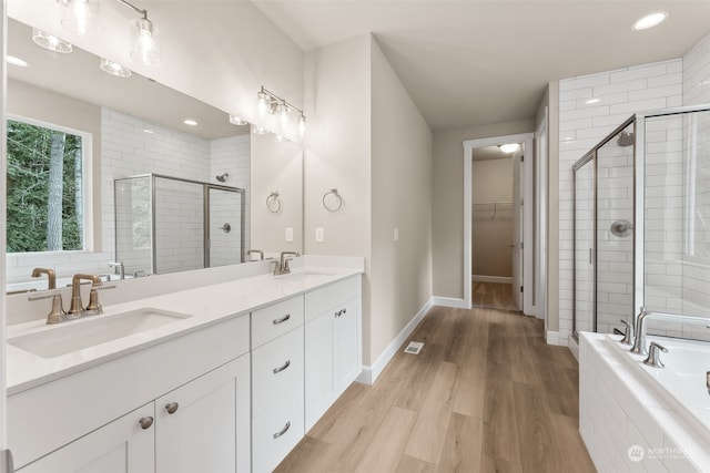 bathroom with vanity, independent shower and bath, and hardwood / wood-style flooring