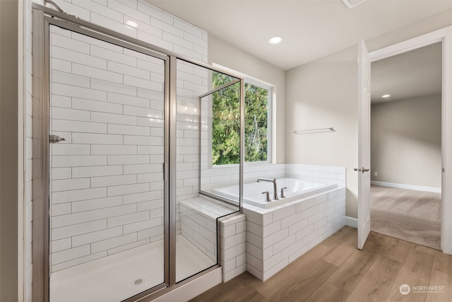 bathroom with wood-type flooring and separate shower and tub