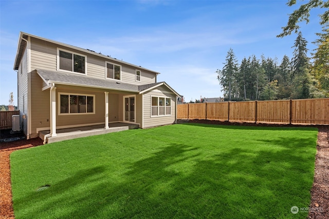 back of property with a yard and a patio