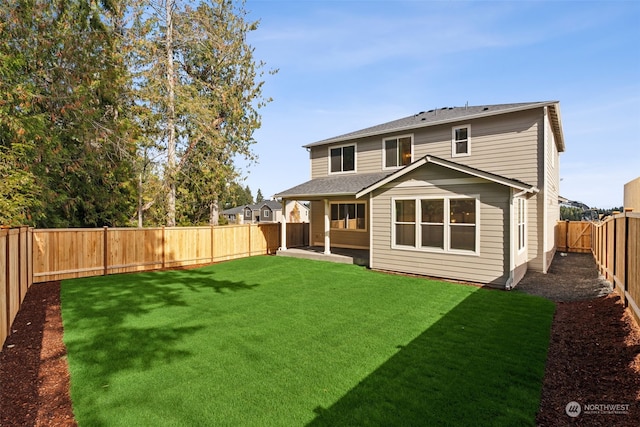 back of house with a lawn