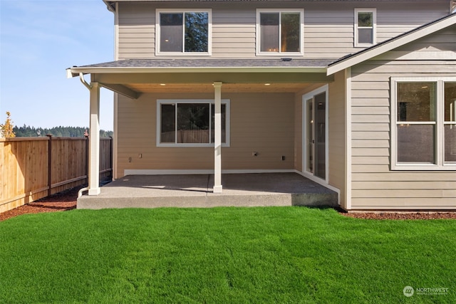 rear view of property featuring a patio and a lawn