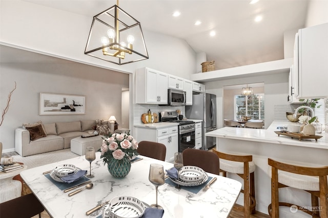 dining room featuring high vaulted ceiling, sink, and an inviting chandelier