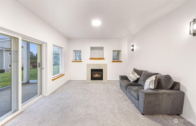 carpeted living room featuring a tiled fireplace