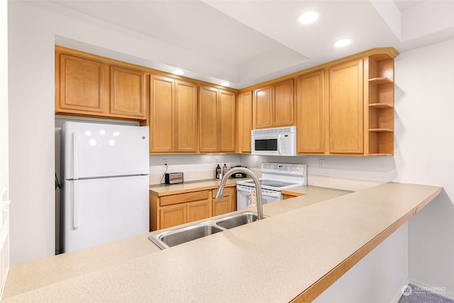 kitchen with kitchen peninsula, white appliances, a tray ceiling, and sink