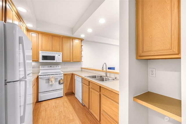 kitchen with light wood-type flooring, white appliances, and sink