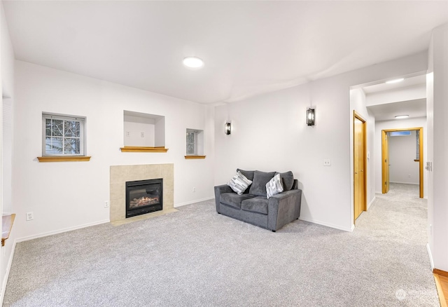 living room with a tile fireplace and light colored carpet