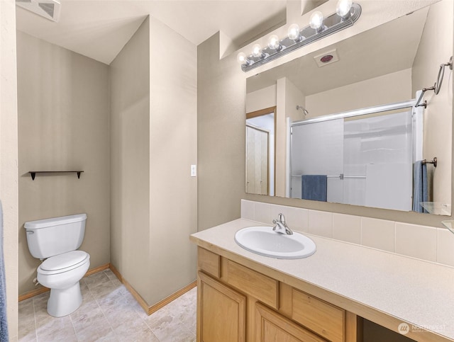 bathroom featuring tile patterned floors, vanity, toilet, and an enclosed shower