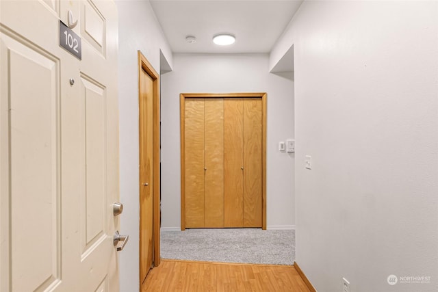 hallway with light hardwood / wood-style floors