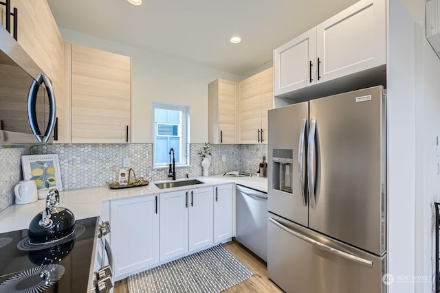 kitchen with sink, decorative backsplash, light brown cabinets, and appliances with stainless steel finishes