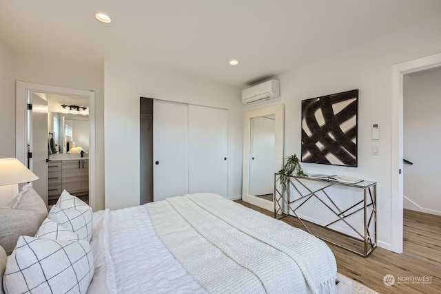 bedroom featuring hardwood / wood-style flooring, a closet, and an AC wall unit