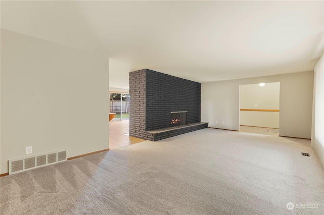 unfurnished living room with light carpet and a fireplace