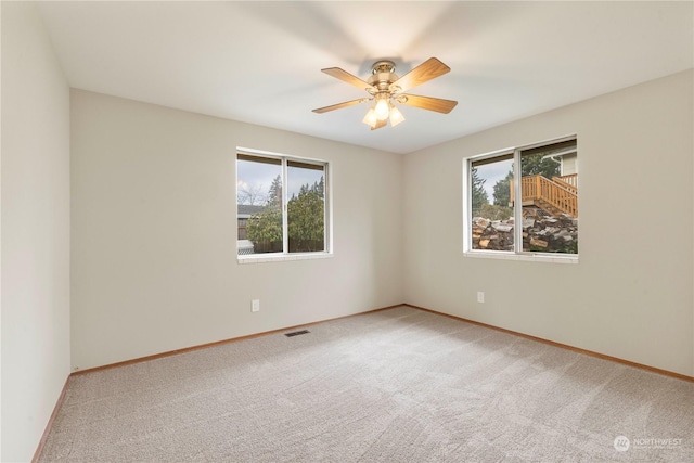 unfurnished room featuring carpet flooring, plenty of natural light, and ceiling fan