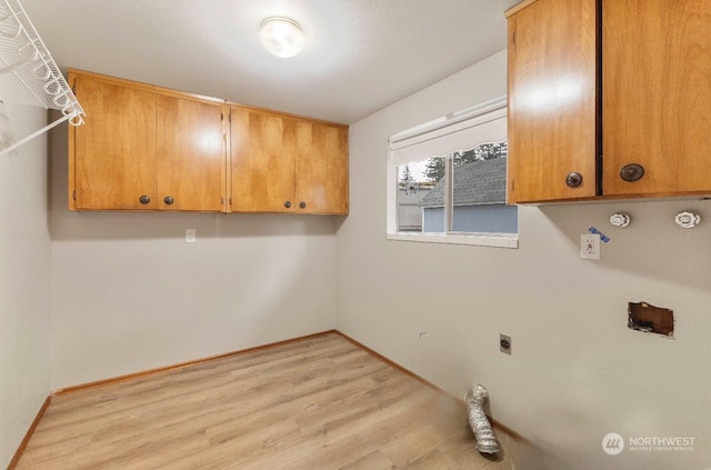 washroom with electric dryer hookup, gas dryer hookup, light hardwood / wood-style flooring, and cabinets