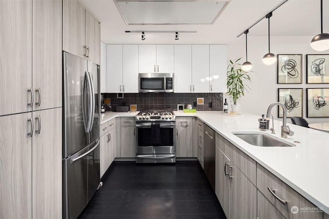 kitchen with sink, hanging light fixtures, tasteful backsplash, dark hardwood / wood-style flooring, and appliances with stainless steel finishes