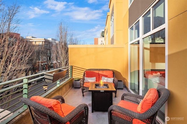 view of patio featuring a balcony and an outdoor fire pit