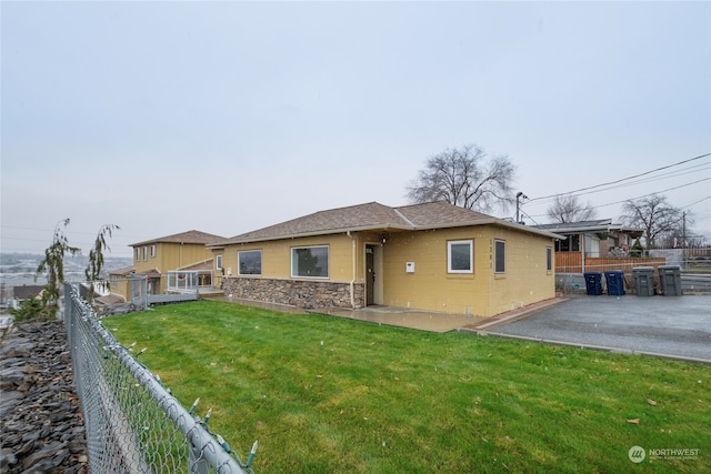 back of property featuring a lawn and a patio area