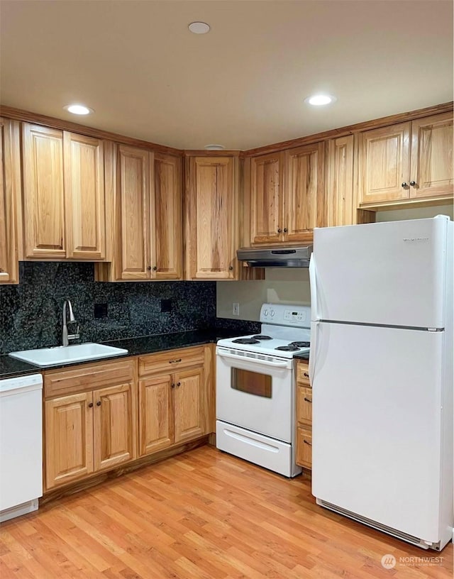 kitchen with decorative backsplash, sink, light hardwood / wood-style floors, and white appliances