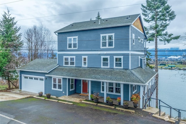 front of property featuring a garage and a water view