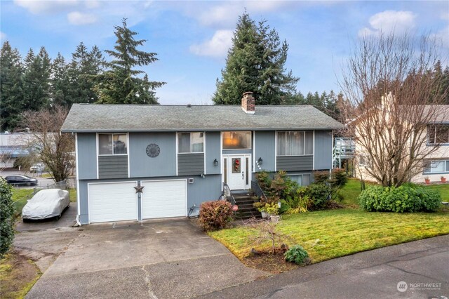 bi-level home with a garage and a front lawn