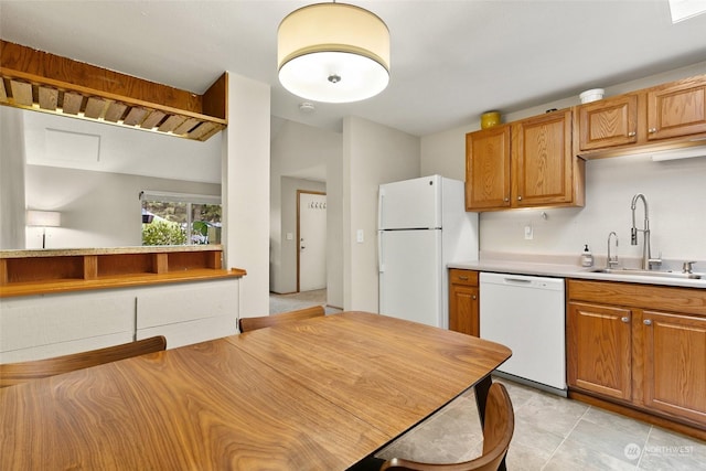 kitchen featuring light tile patterned flooring, white appliances, and sink