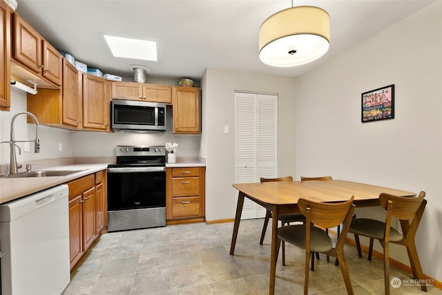 kitchen featuring sink, stainless steel appliances, and a skylight