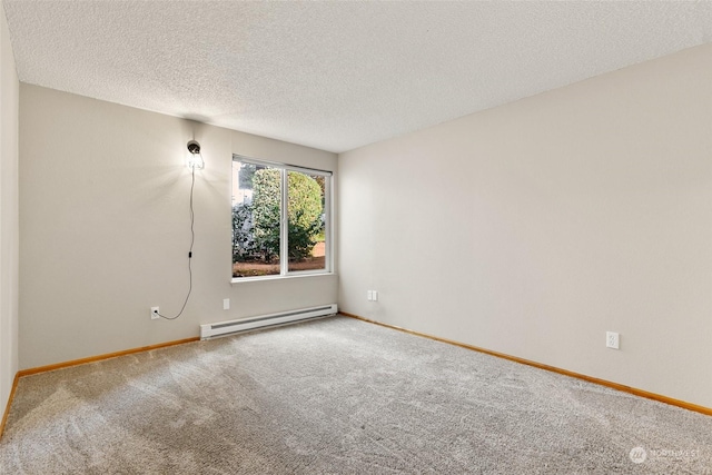 carpeted spare room with a textured ceiling and a baseboard heating unit