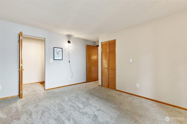 carpeted empty room featuring a textured ceiling