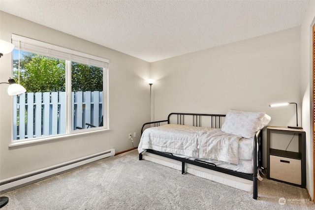 carpeted bedroom with a textured ceiling and a baseboard radiator