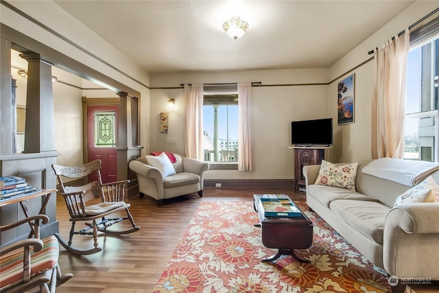 living room with hardwood / wood-style floors and ornate columns