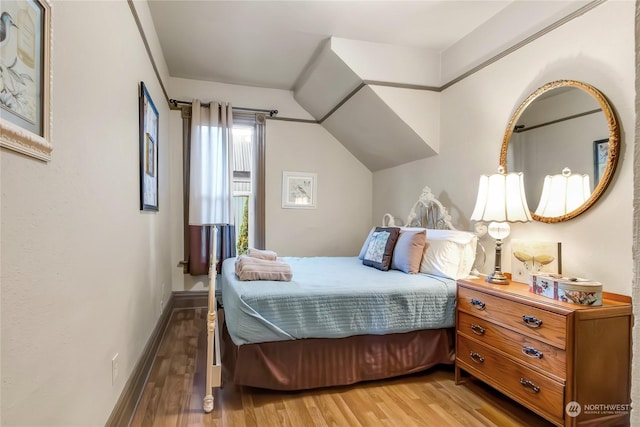 bedroom with hardwood / wood-style flooring and vaulted ceiling