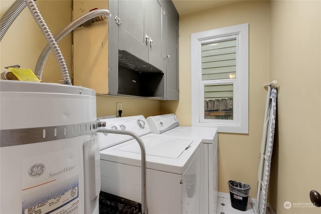 washroom with washing machine and dryer and cabinets