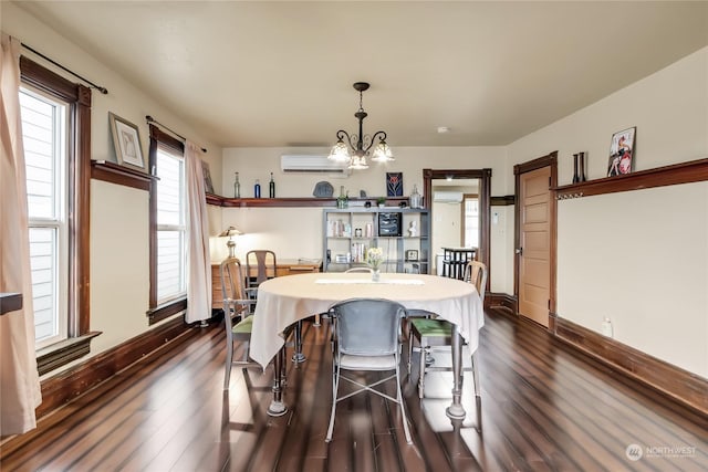 dining area with dark wood-type flooring, a wall mounted air conditioner, and a notable chandelier