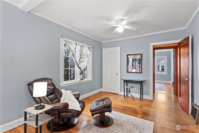 sitting room featuring light wood-type flooring, ceiling fan, and ornamental molding