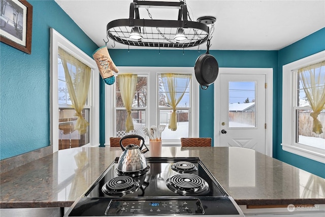 kitchen featuring dark stone countertops and black range