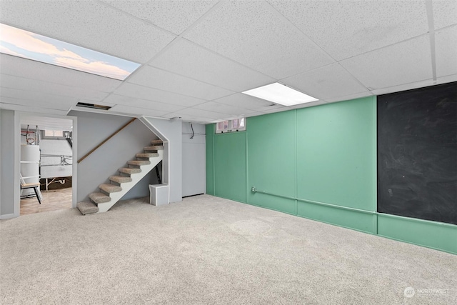 basement featuring carpet and a paneled ceiling