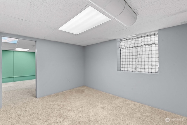 unfurnished room featuring carpet flooring and a paneled ceiling